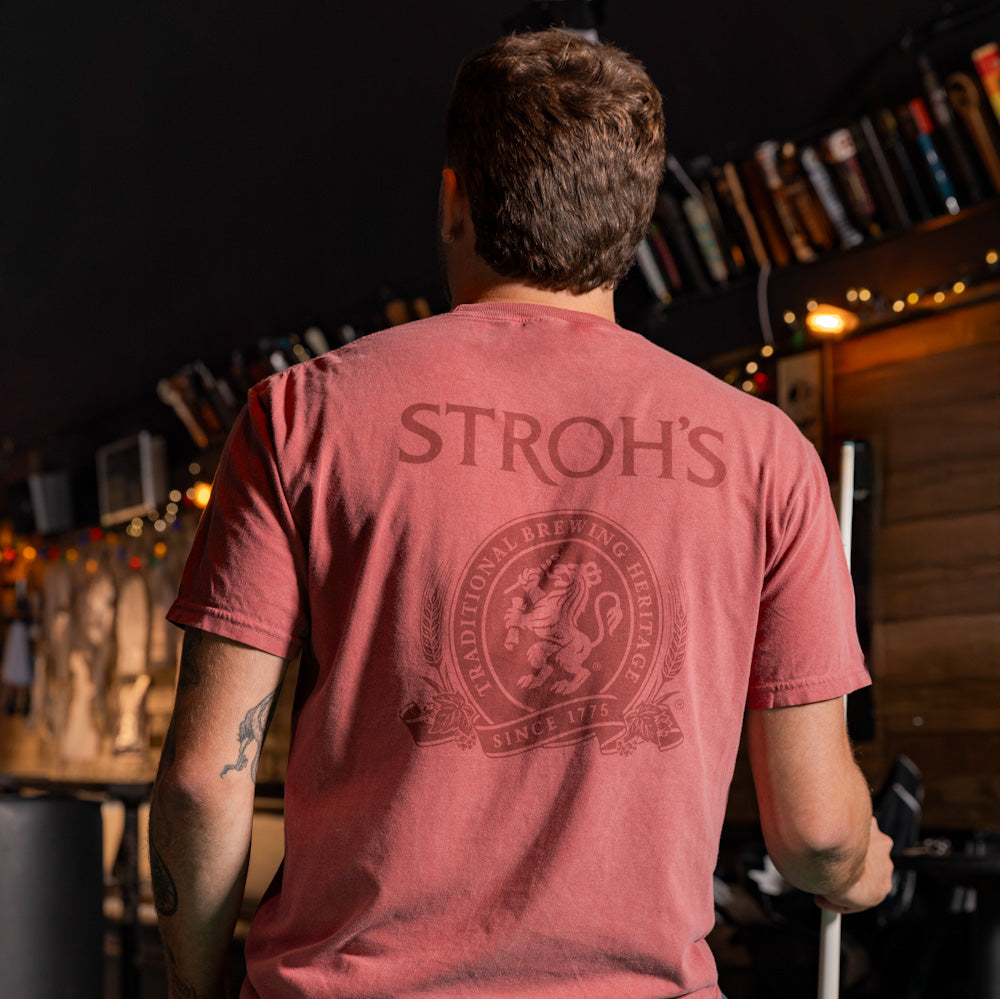 Man wearing a red 'Stroh's' t-shirt in a bar setting