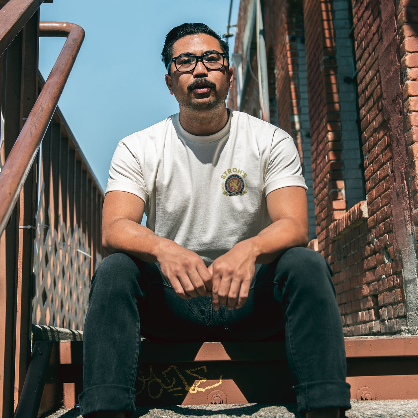 man sitting on steps with vintage white seal tee on 